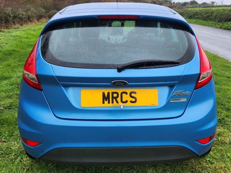A blue Ford Fiesta viewed from the back