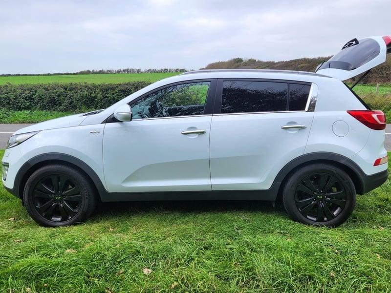 A white Kia Sportage viewed from the left side