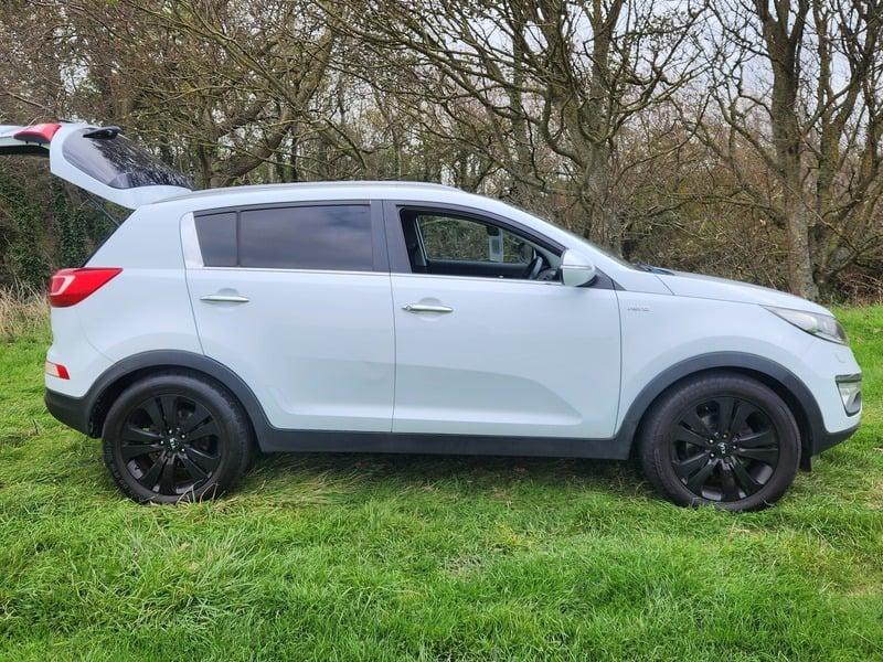 A white Kia Sportage viewed from the right side