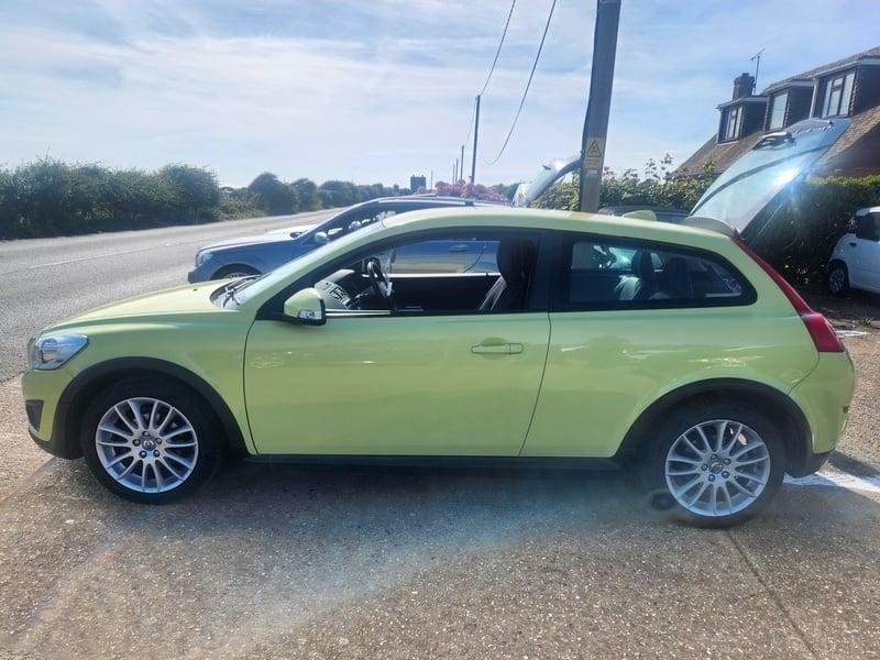 A yellow Volvo C30 LUX SE viewed from the left side