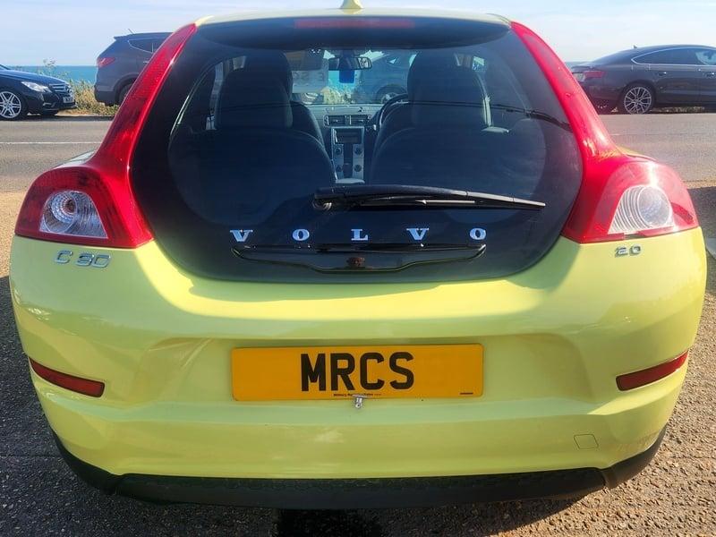 A lime yellow Volvo C30 LUX SE viewed from the back
