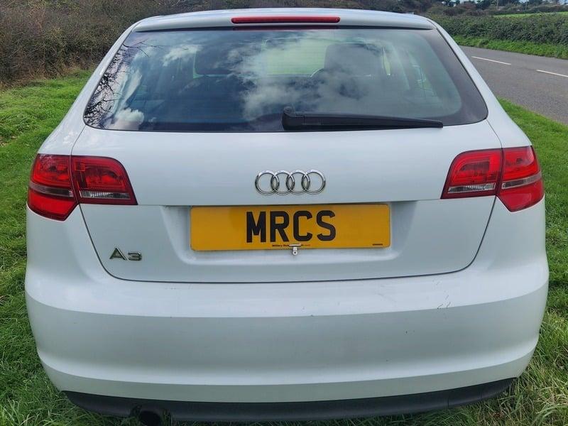 A white Audi A3 Sportback viewed from the back