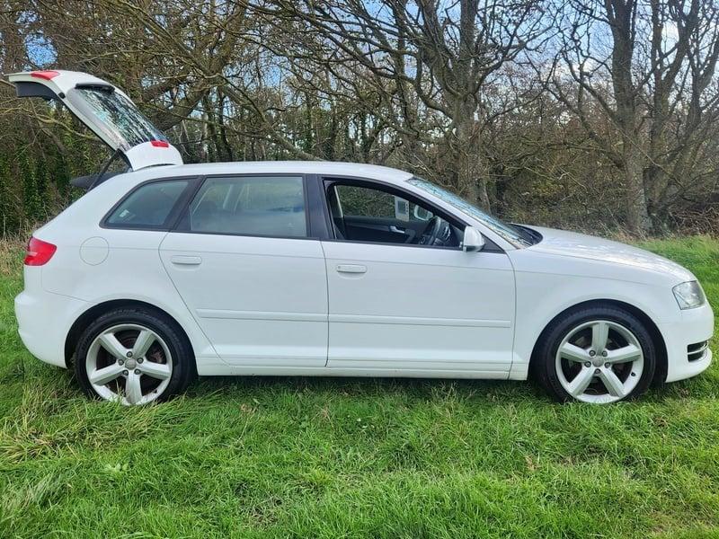 A white Audi A3 Sportback viewed from the right side
