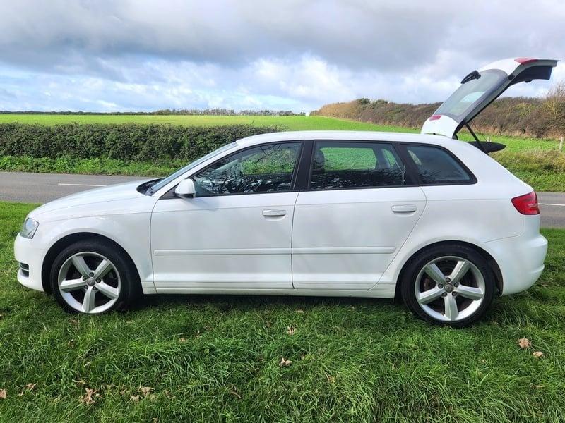 A white Audi A3 Sportback viewed from the left side
