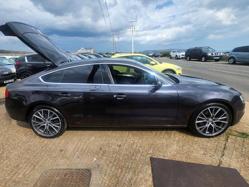A monsoon grey Audi A5 Technik Sportback viewed from the right side