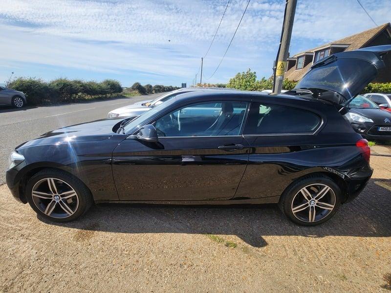 A jet black BMW 116i Sport viewed from the left side