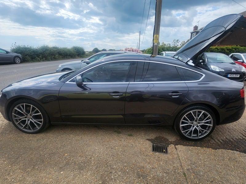 A monsoon grey Audi A5 Technik Sportback viewed from the left side