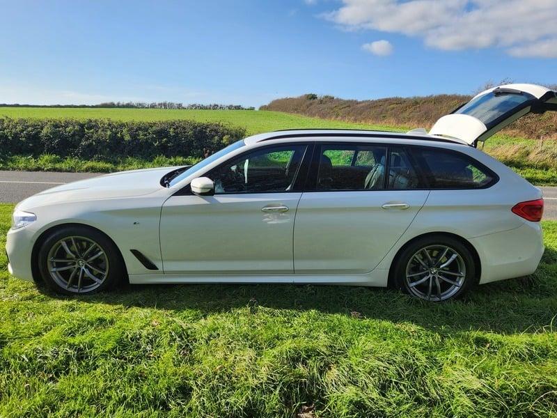The left side of a white BMW 5 Series car