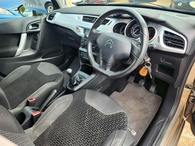 Front seats, steering wheel, and controls of a gold Citroen C3 VTR+