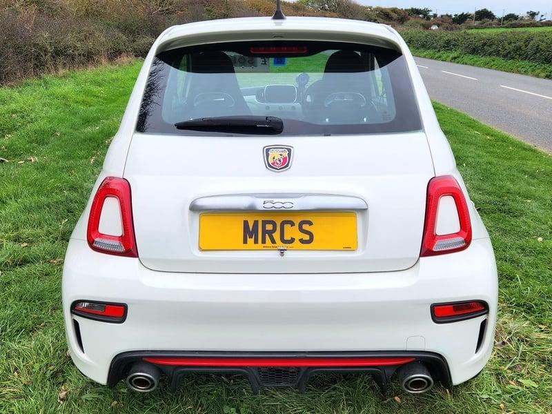 A white Fiat Abarth viewed from the back