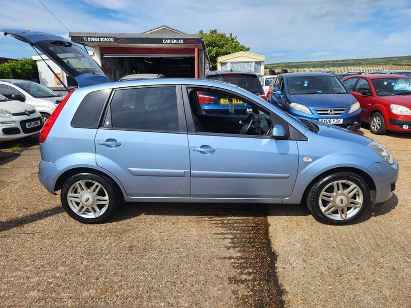 A blue Ford Fiesta 1.6 Ghia viewed from the right side