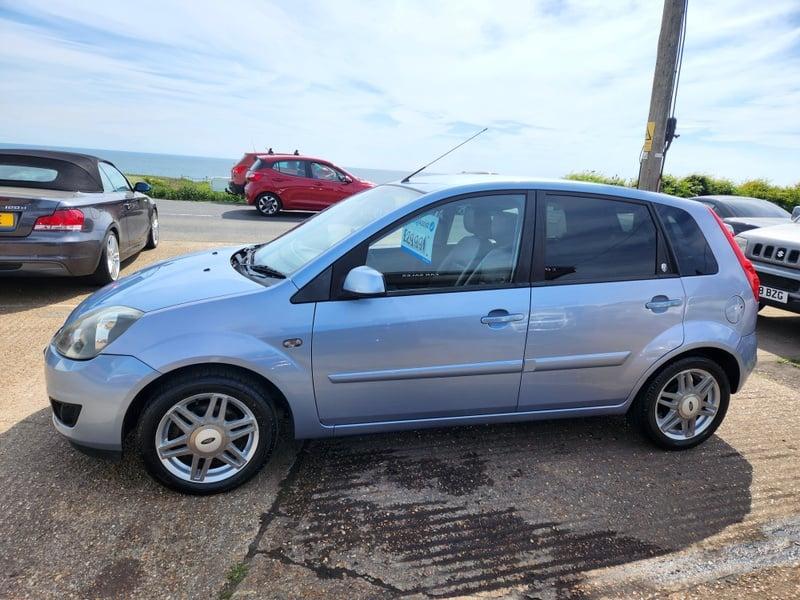 A blue Ford Fiesta 1.6 Ghia viewed from the left side