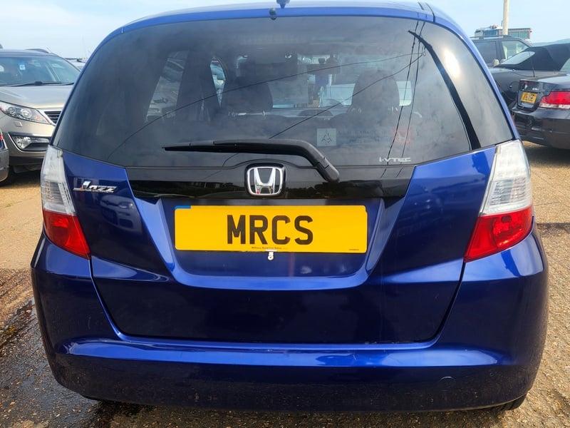 A blue Honda Jazz viewed from the outside back