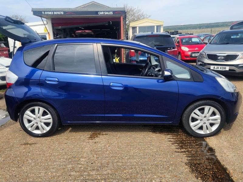 A blue Honda Jazz viewed from the outside right