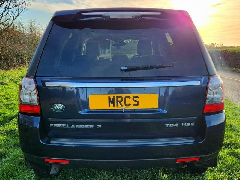 A metallic blue Land Rover Freelander viewed from the outside back