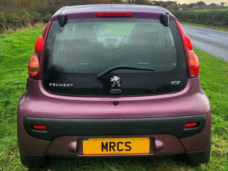 A plum purple Peugeot 107 viewed from the outside back