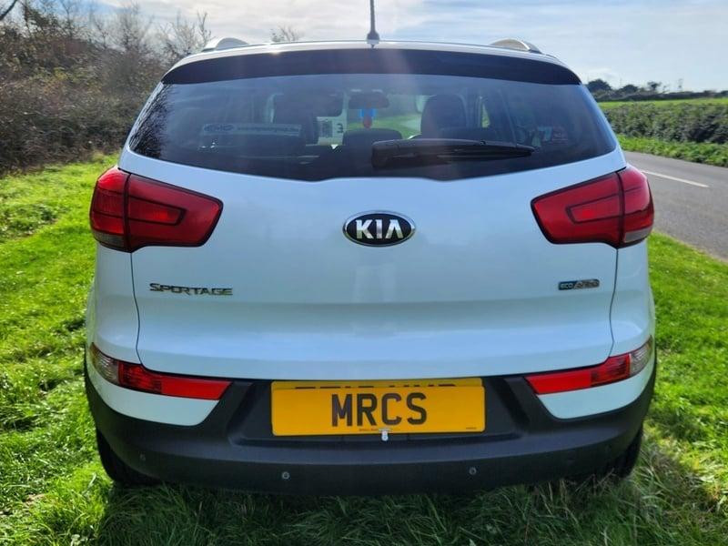 A white KIA Sportage viewed from the outside back
