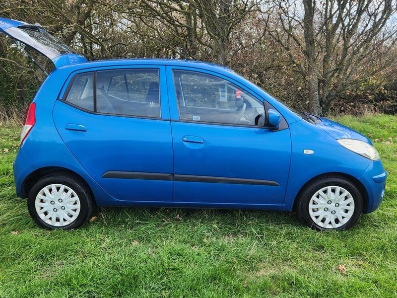 A blue Hyundai i-10 ES viewed from the outside right