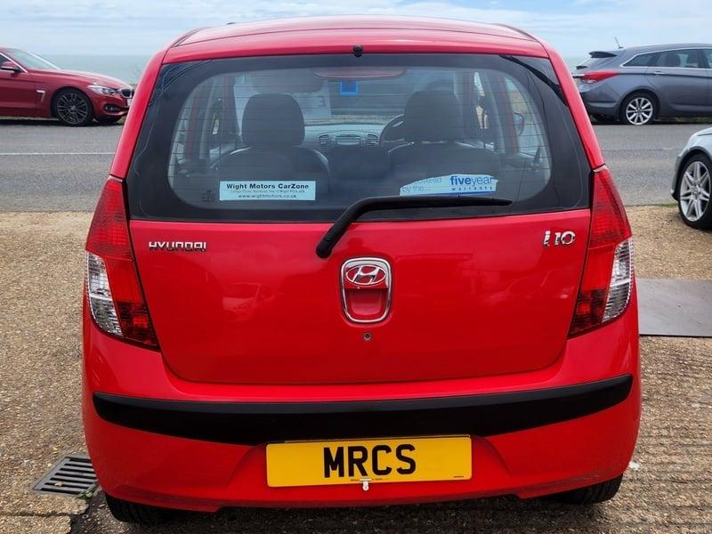 A red Hyundai I-10 Classic viewed from the outside back