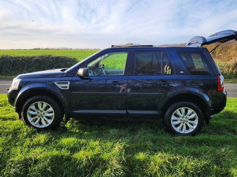 A metallic blue Land Rover Freelander viewed from the outside left