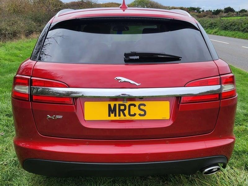 An odyssey red metallic Jaguar XF Sportback viewed from the outside back