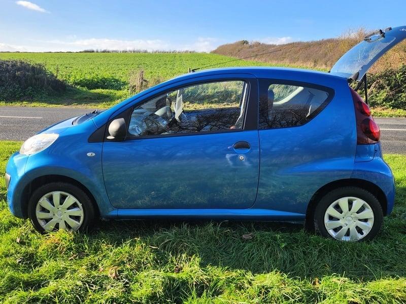 An Aegean Blue Peugeot 107 viewed from the outside left