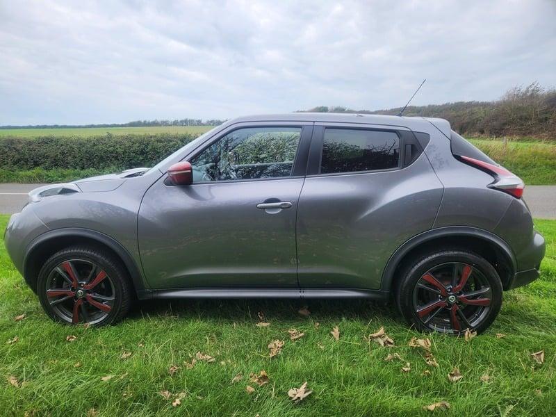 A grey and cerise Nissan Juke 1.5 dCi Acenta Premium viewed from the outside left