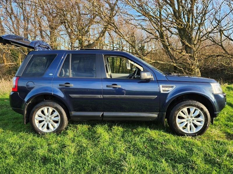 A metallic blue Land Rover Freelander viewed from the outside right