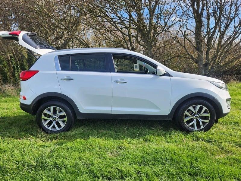 A white KIA Sportage viewed from the outside right