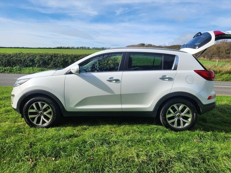 A white KIA Sportage viewed from the outside left