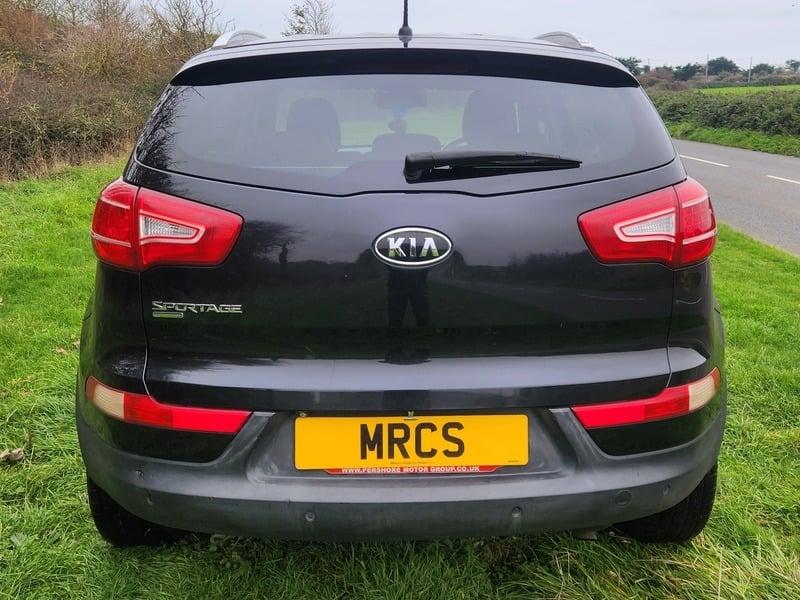 A black KIA Sportage viewed from the outside back