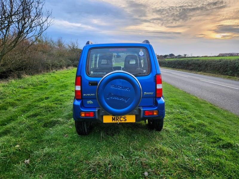 A blue Suzuki Jimny 1.3 VVT JLX viewed from behind
