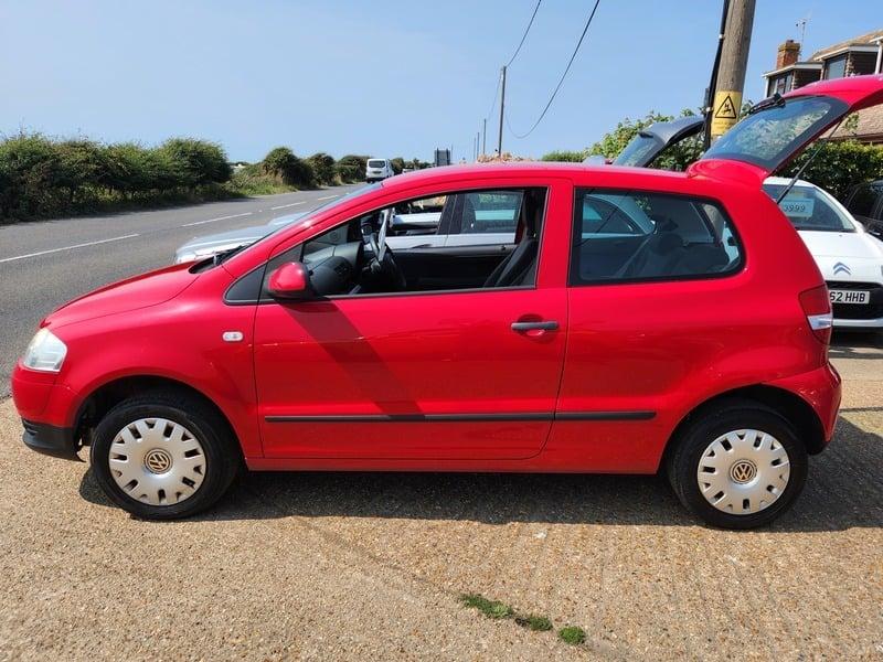 A red Volkswagen Fox viewed from the left side