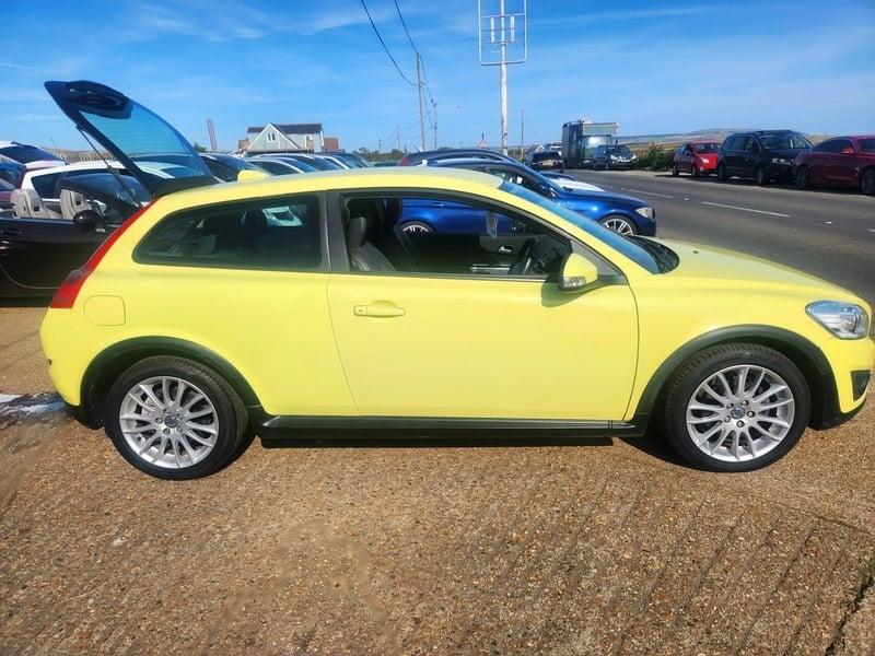 A yellow Volvo C30 LUX SE viewed from the right side