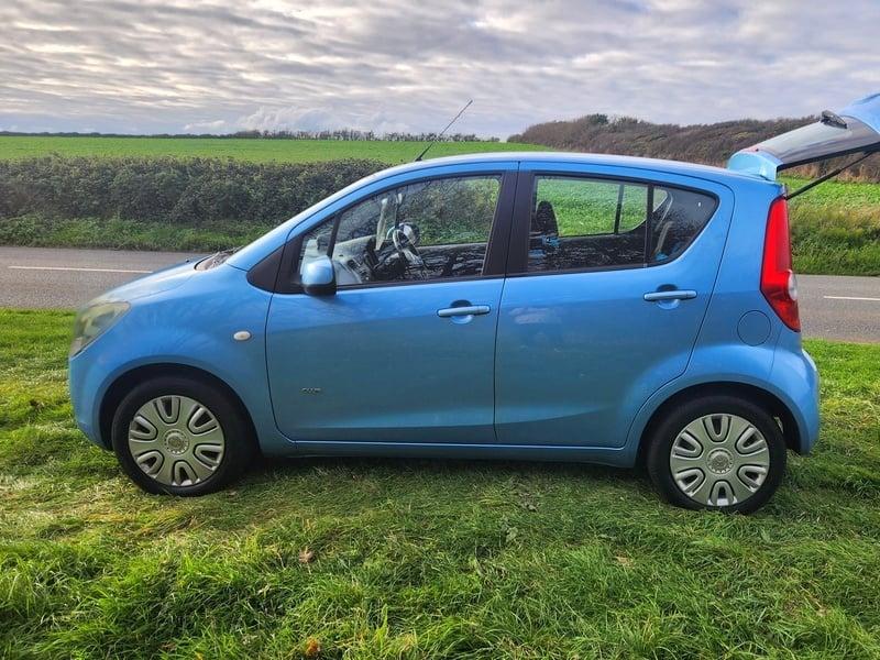 A blue Vauxhall Agila viewed from the left side