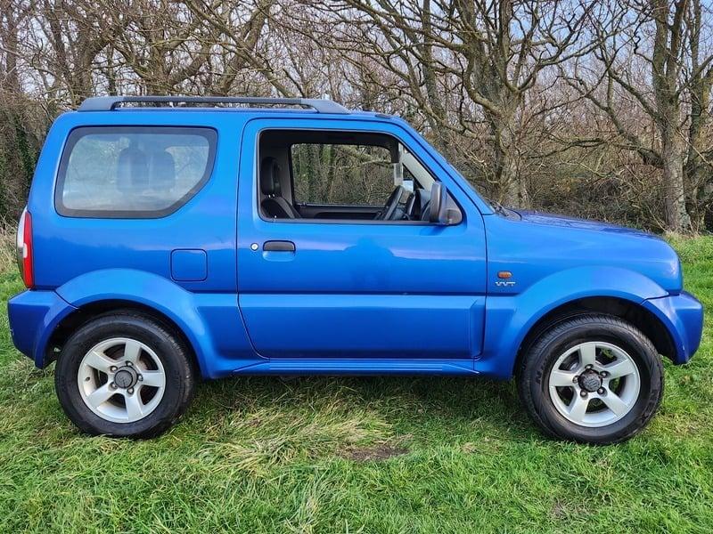 A blue Suzuki Jimny 1.3 VVT JLX viewed from the right side