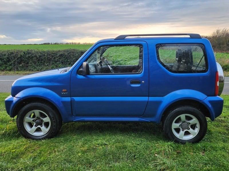 A blue Suzuki Jimny 1.3 VVT JLX viewed from the left side