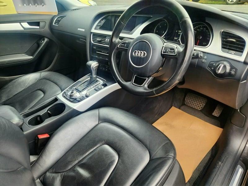 The front seats, steering wheel, and controls of an Audi A5 Sportback from the right