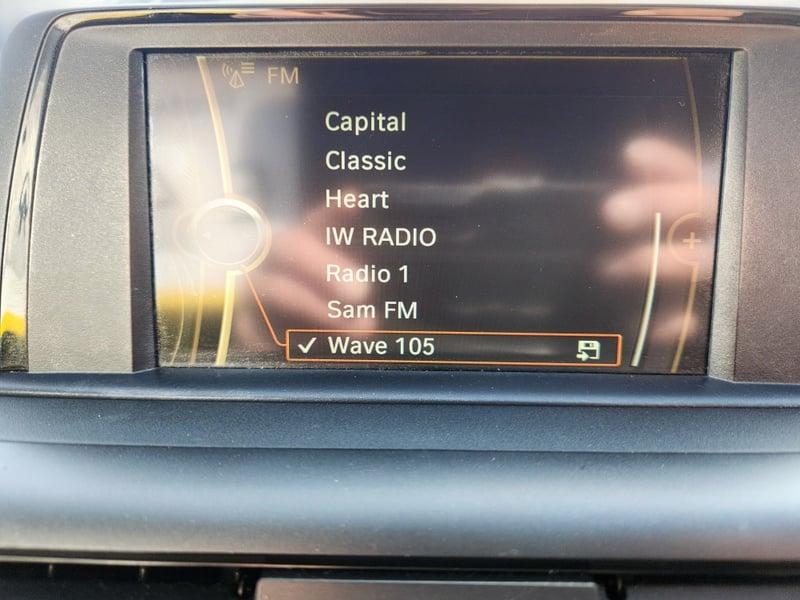 The central display panel of a BMW 1 Series 116i Sport showing radio channels