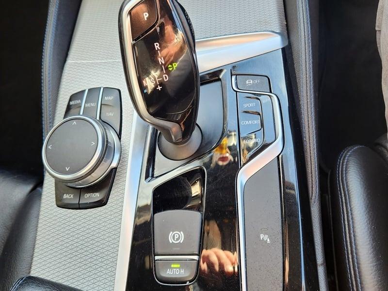 The gear stick and center lower console of a BMW 5 Series Touring 520d M Sport Auto