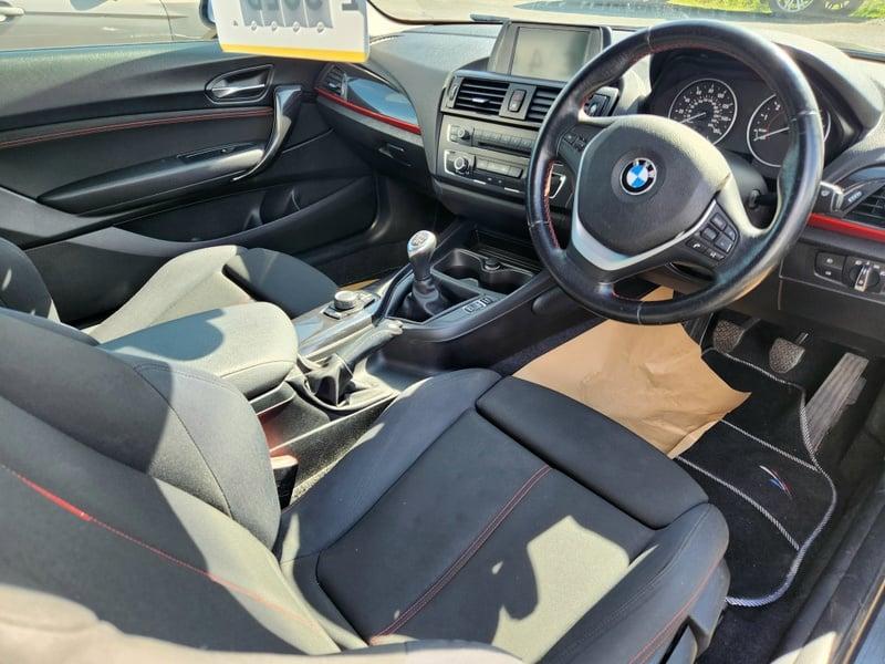 The front seats, steering wheel and controls of a BMW 1 Series 116i Sport