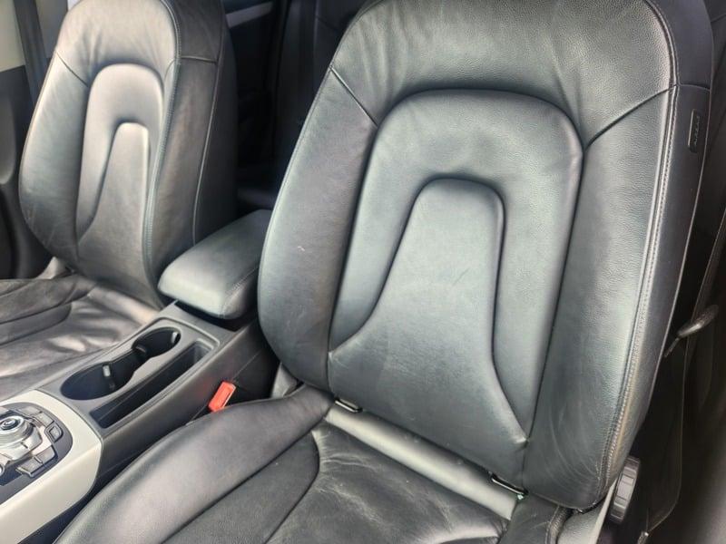 The front seats and lower center console of a monsoon grey Audi A5 Sportback from the left