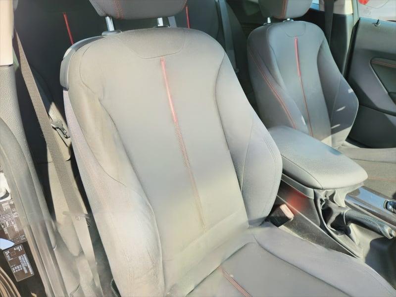 The front seat and center console of a BMW 1 Series 116i Sport from the right