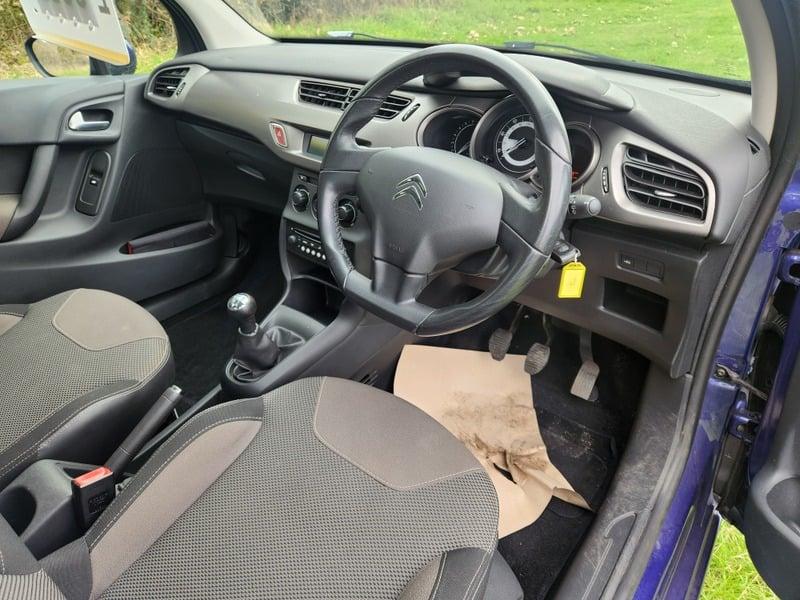 The front seats, steering wheel, and controls of a Citroen C3 VTi VTR+ from the right