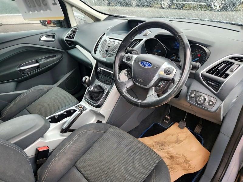 The front seats, steering wheel, and controls of a silver Ford C Max 1.6 TDCi, from the right side.