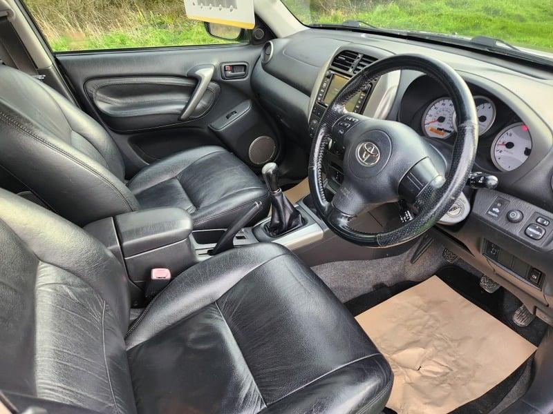 The front seats, steering wheel, and controls on a Eclipse Black Toyota Rav-4 2.0 XT5, viewed from the right side.