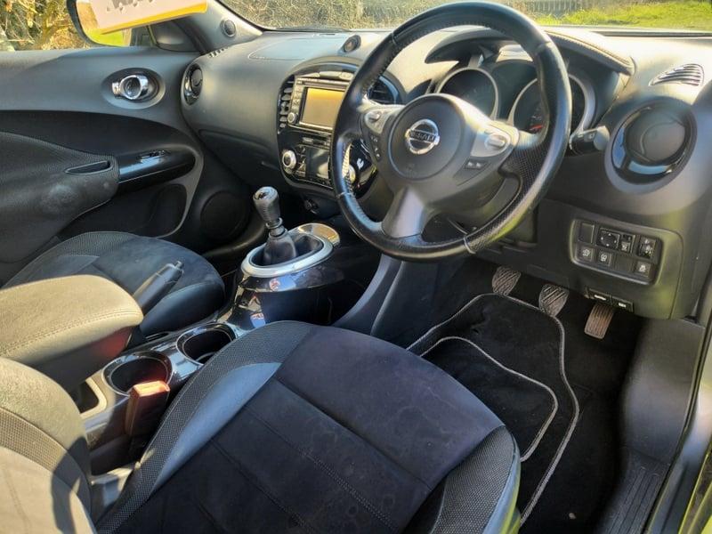 The front seats, steering wheel, and controls on a grey Nissan Juke 1.5, viewed from the right side.