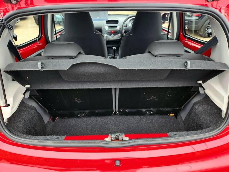 The boot of a red Peugeot 107 Urban, viewed from behind.