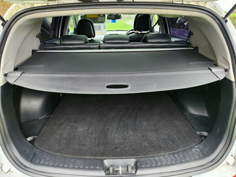 The boot of a white Kia Rio Sportage 2.0 CRDi KX-3, viewed from behind.