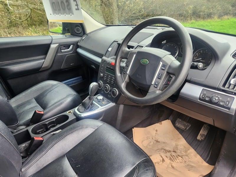 The front seats, steering wheel, and controls on a Land Rover Freelander, viewed from the right side.
